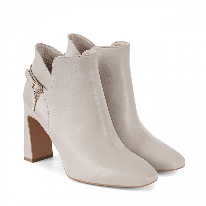 Cream-colored ankle boots with square toes and a sturdy block heel