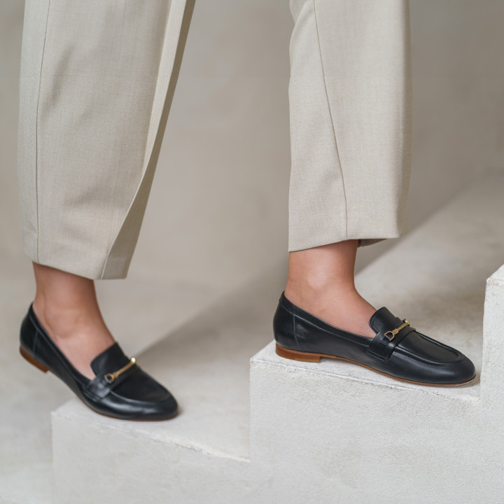 Black moccasins with a flat sole made of natural grain leather