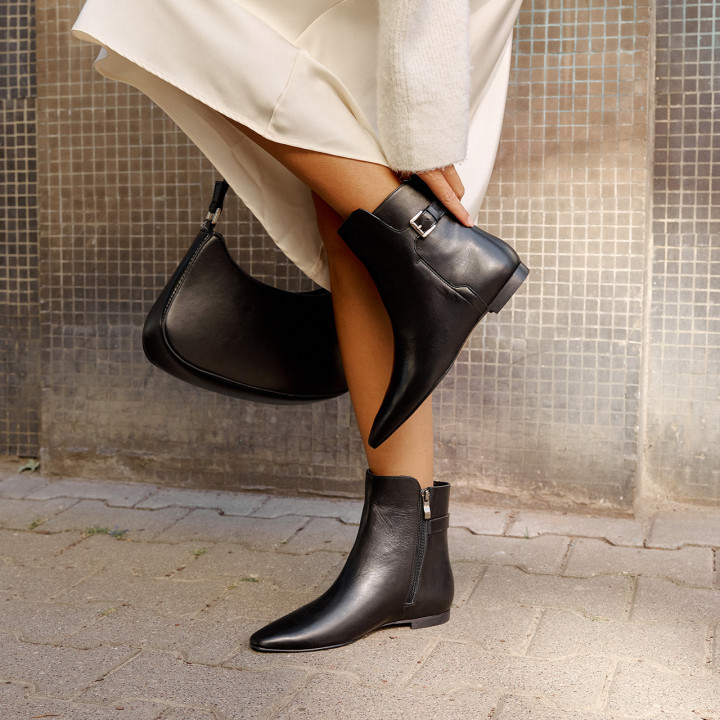 Black boots with a flat sole and square toes made of natural grain leather