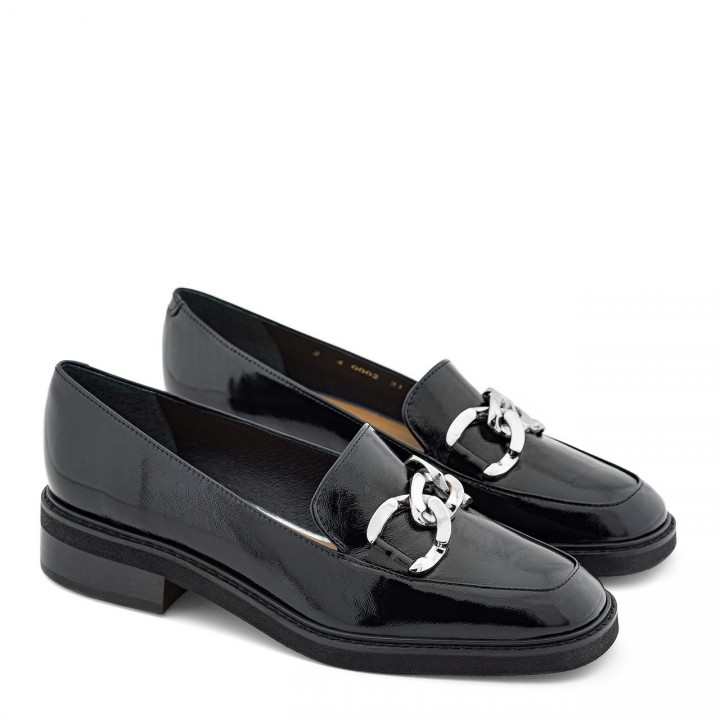 Black low-heeled moccasins with a silver chain at the front